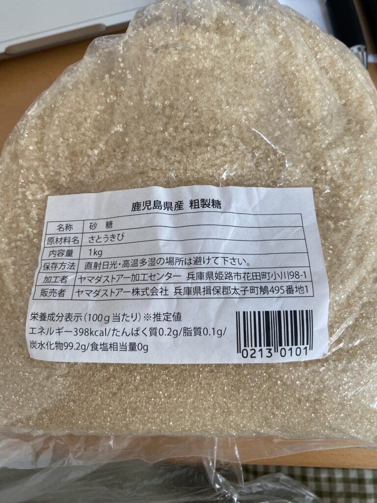 鹿児島県産 粗製糖の袋の裏の表示。原材料名はさとうきびのみ。栄養成分表示はエネルギー・たんぱく質・脂質・炭水化物・食塩相当量の5項目だけで、ミネラルの記載はない