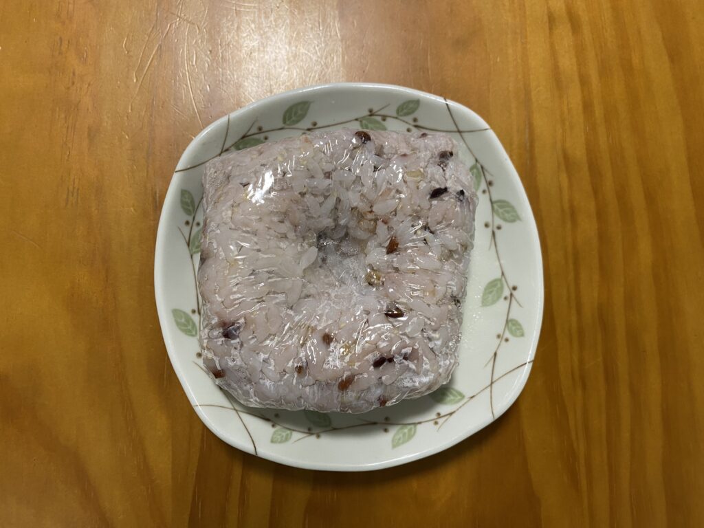 ラップで包んだ冷凍ご飯。真ん中が少しくぼんでいる